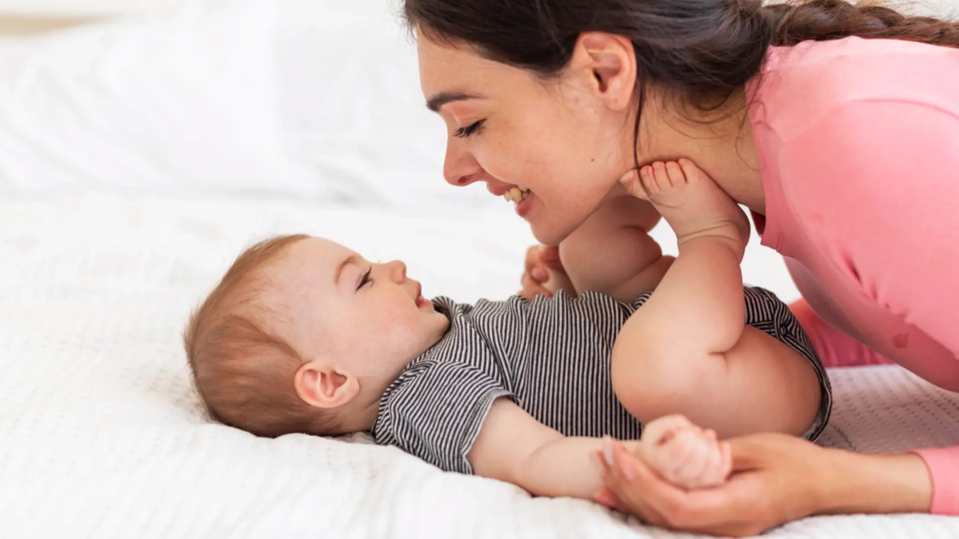 Smiling Mother sleep with Newborn on White Blanket. Dreaming Mom hugging Baby lying down on Stomach. Happy Motherhood and Parenting. Infant Health Care. Child Protection - Stock Photo & Image